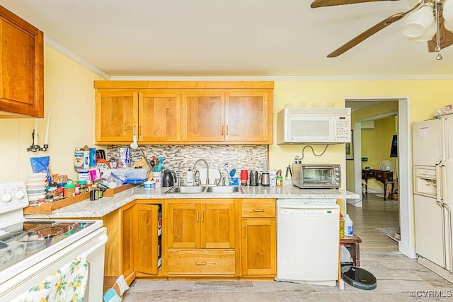 kitchen with ceiling fan, white appliances, ornamental molding, a sink, and backsplash