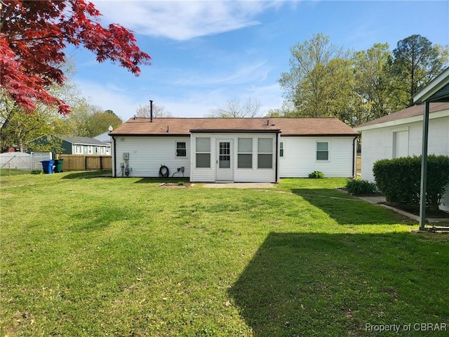 back of house featuring a yard and fence