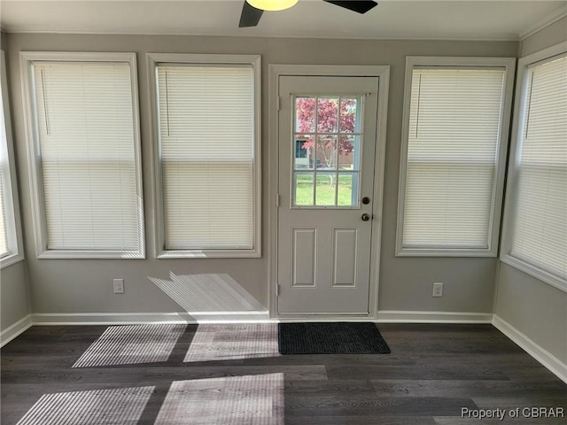 doorway to outside with dark wood-style floors, baseboards, crown molding, and a ceiling fan