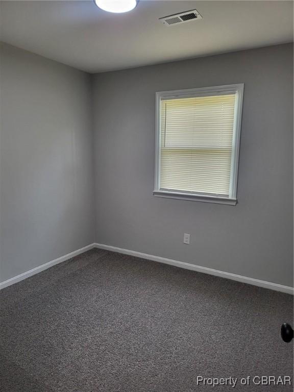 carpeted empty room featuring baseboards and visible vents