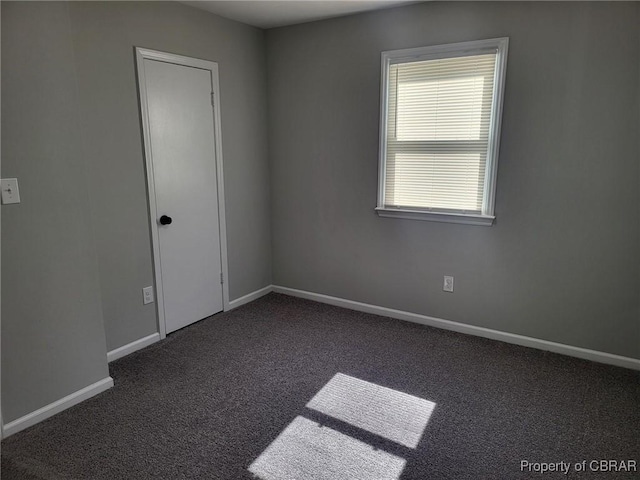carpeted spare room featuring baseboards