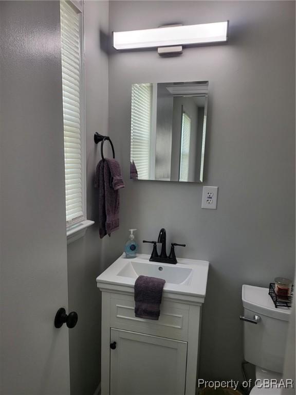 bathroom featuring toilet, plenty of natural light, and vanity