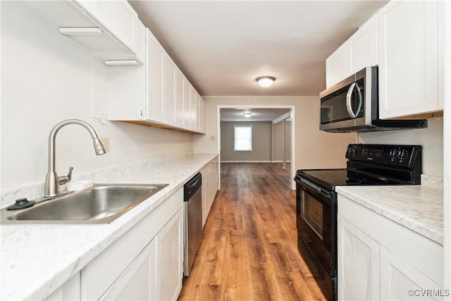 932 Eastern View Rd, King & Queen, VA 23148 - kitchen with white cabinetry, light wood finished floors, stainless steel appliances, and a sink