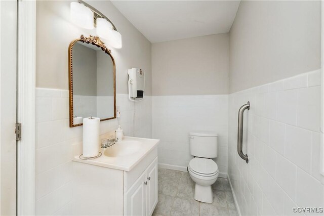 932 Eastern View Rd, King & Queen, VA 23148 - bathroom featuring tile walls, toilet, vanity, and wainscoting