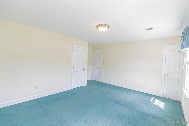spare room featuring light colored carpet, baseboards, and visible vents