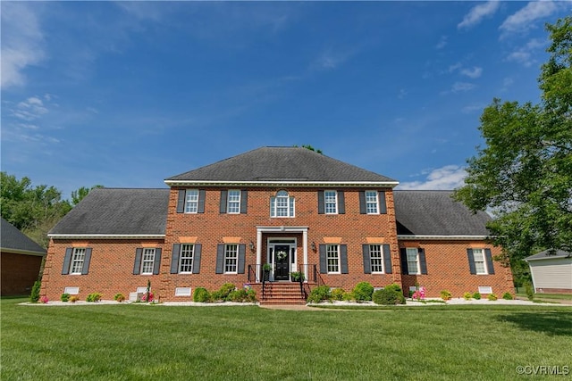 view of front of house featuring brick siding and a front yard