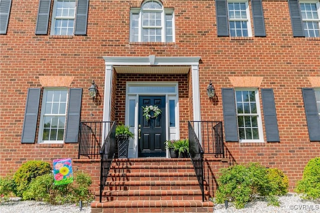 entrance to property featuring brick siding