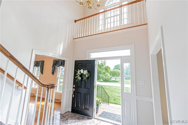 entrance foyer featuring a notable chandelier, stairs, and a towering ceiling