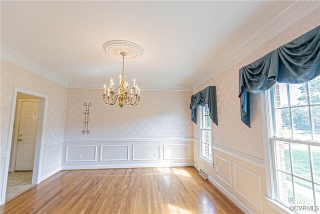 interior space with a wainscoted wall, light wood-type flooring, wallpapered walls, and a chandelier
