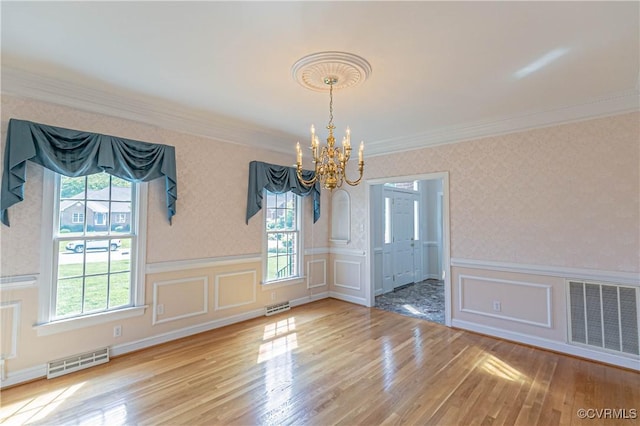 unfurnished dining area featuring a notable chandelier, visible vents, and wallpapered walls