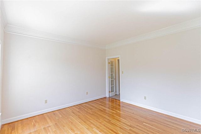 spare room featuring light wood-style floors, ornamental molding, and baseboards