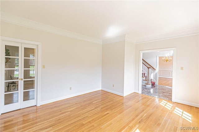 unfurnished room with ornamental molding, stairs, baseboards, light wood finished floors, and a notable chandelier