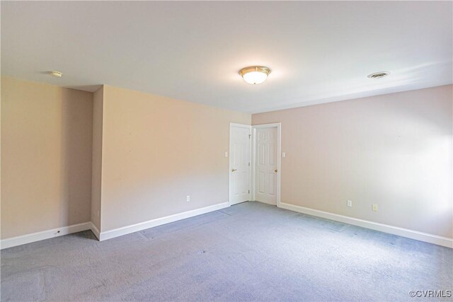 spare room featuring visible vents, carpet flooring, and baseboards