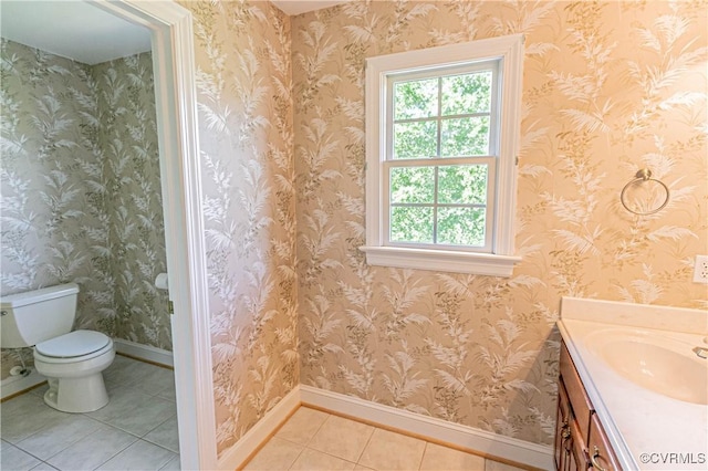 bathroom with toilet, tile patterned floors, baseboards, and vanity