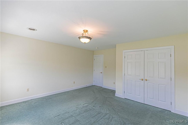 unfurnished bedroom with baseboards, carpet, visible vents, and a closet