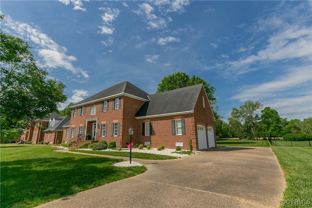 exterior space with brick siding, a garage, a front lawn, and driveway