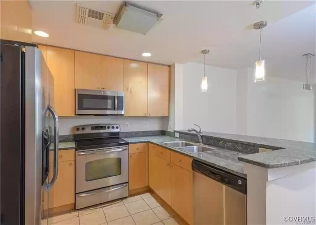 kitchen featuring a sink, light brown cabinetry, a peninsula, appliances with stainless steel finishes, and visible vents