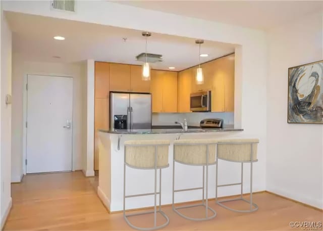kitchen with recessed lighting, visible vents, baseboards, a peninsula, and appliances with stainless steel finishes