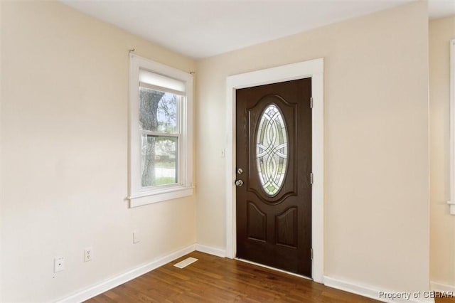 entrance foyer featuring dark wood-style flooring, visible vents, and baseboards