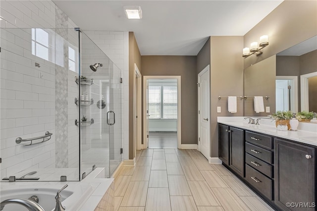 full bathroom featuring a sink, double vanity, baseboards, a shower stall, and a bath