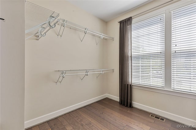 walk in closet with hardwood / wood-style flooring and visible vents