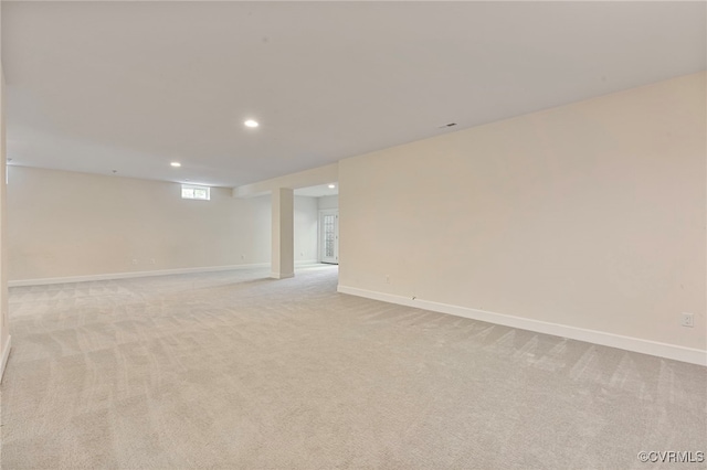 empty room featuring recessed lighting, baseboards, and light colored carpet