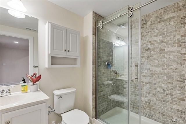 full bathroom with vanity, a stall shower, visible vents, and toilet