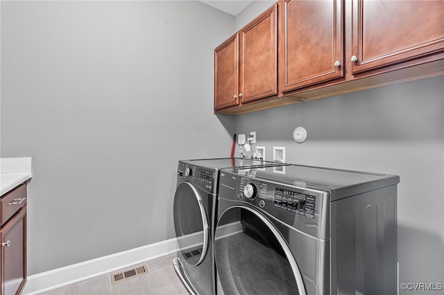 laundry area featuring cabinet space, independent washer and dryer, tile patterned flooring, baseboards, and visible vents