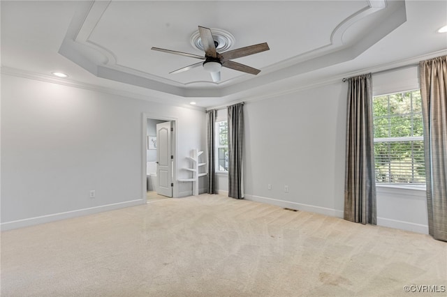 unfurnished bedroom with carpet floors, ornamental molding, a raised ceiling, and baseboards