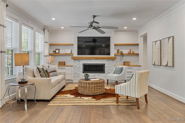 living room featuring wood-type flooring, baseboards, ornamental molding, and ceiling fan
