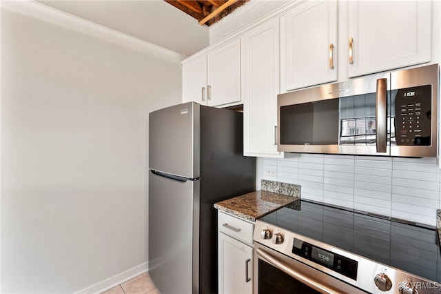 1716 Summit Ave Unit 30, Richmond, VA 23230 - kitchen with dark stone countertops, stainless steel appliances, white cabinetry, light tile patterned floors, and backsplash
