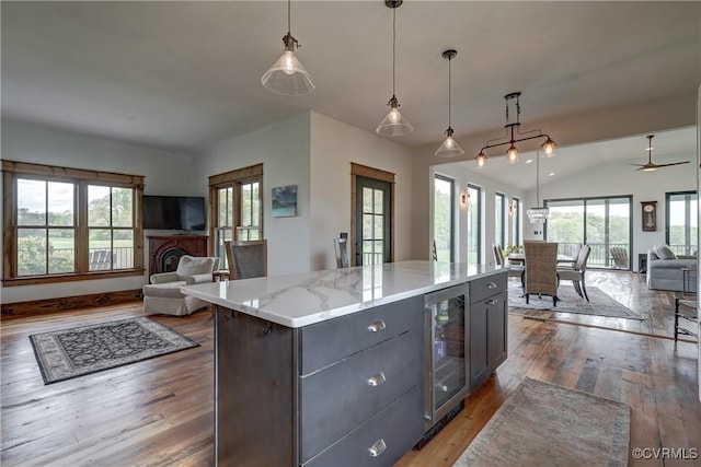kitchen featuring open floor plan, wine cooler, wood finished floors, and plenty of natural light