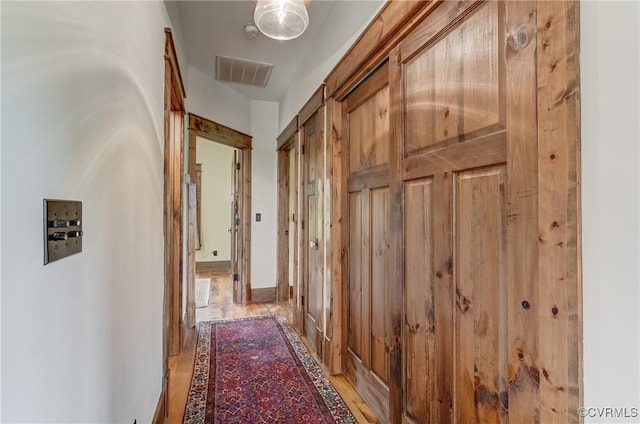 hall with light wood-style floors and visible vents