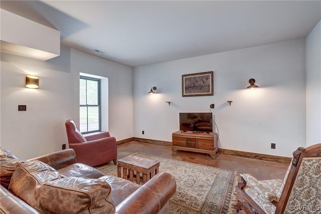 living room with concrete flooring, visible vents, and baseboards