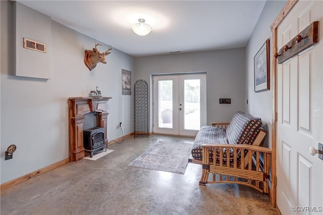 foyer with concrete floors, a wood stove, french doors, baseboards, and visible vents