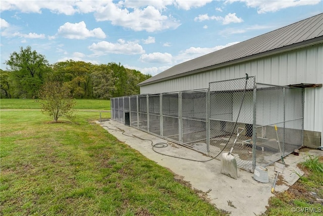 view of side of home with an exterior structure, a lawn, metal roof, and an outdoor structure