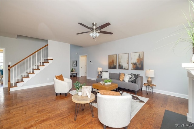 living room featuring baseboards, a ceiling fan, stairs, and wood finished floors