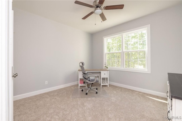 carpeted office space with baseboards and ceiling fan