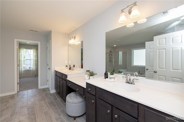 full bathroom with visible vents, a shower stall, wood finished floors, vanity, and baseboards