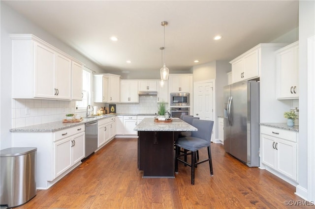 kitchen featuring white cabinetry, a breakfast bar area, a kitchen island, and stainless steel appliances