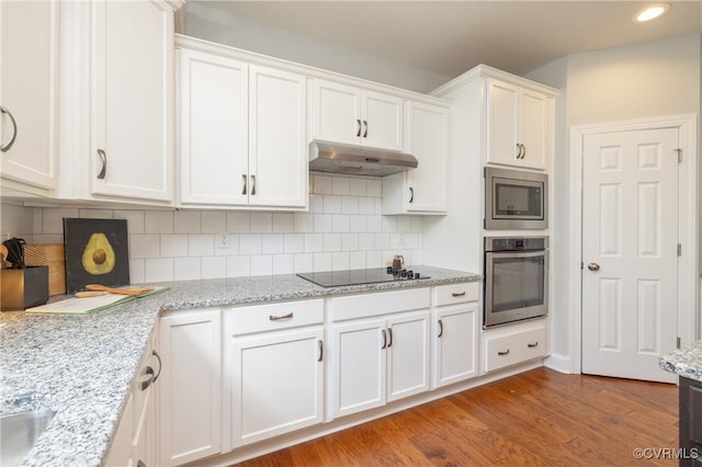 kitchen featuring under cabinet range hood, stainless steel appliances, white cabinets, and wood finished floors