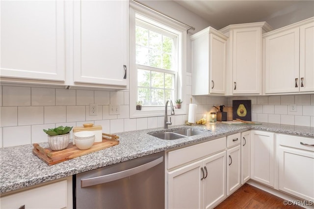 kitchen with a sink, white cabinetry, backsplash, and dishwasher