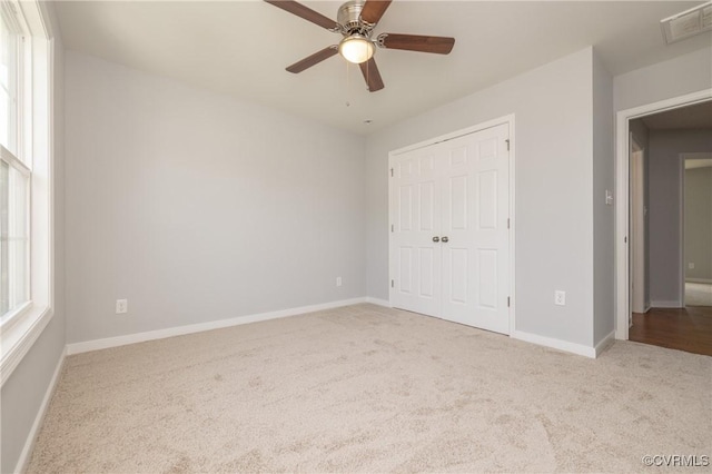 unfurnished bedroom featuring carpet flooring, baseboards, visible vents, and a closet
