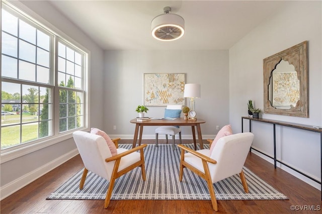 living area with baseboards and wood finished floors