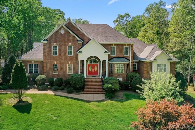 view of front of house featuring brick siding and a front lawn
