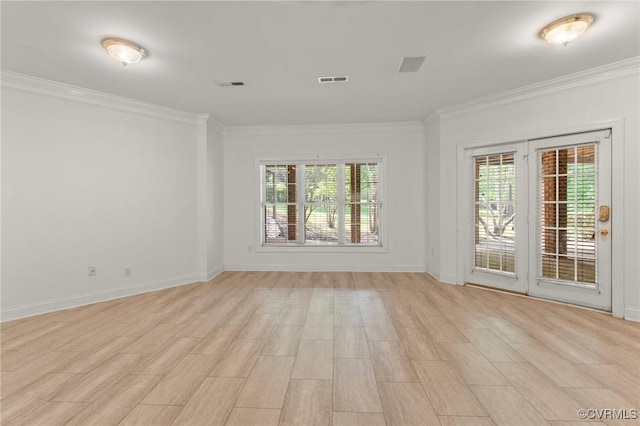 empty room featuring ornamental molding, visible vents, and light wood-style flooring