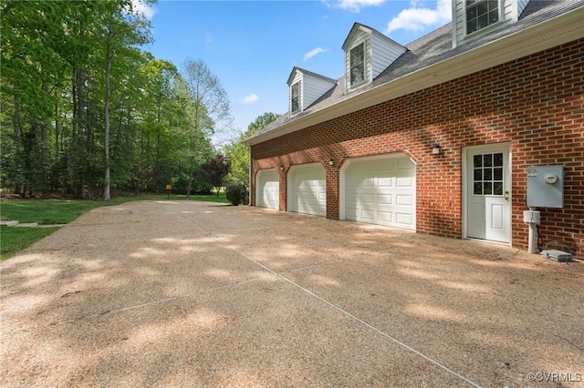 view of home's exterior featuring concrete driveway and brick siding