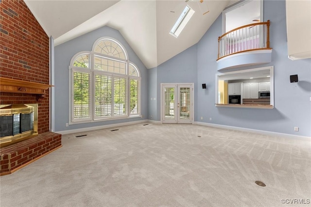 unfurnished living room with baseboards, a skylight, a fireplace, and carpet flooring