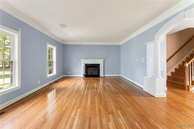 unfurnished living room with a fireplace with flush hearth, stairway, decorative columns, light wood-style flooring, and baseboards