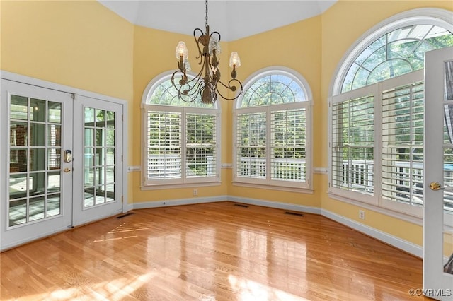 unfurnished sunroom with visible vents, an inviting chandelier, and french doors